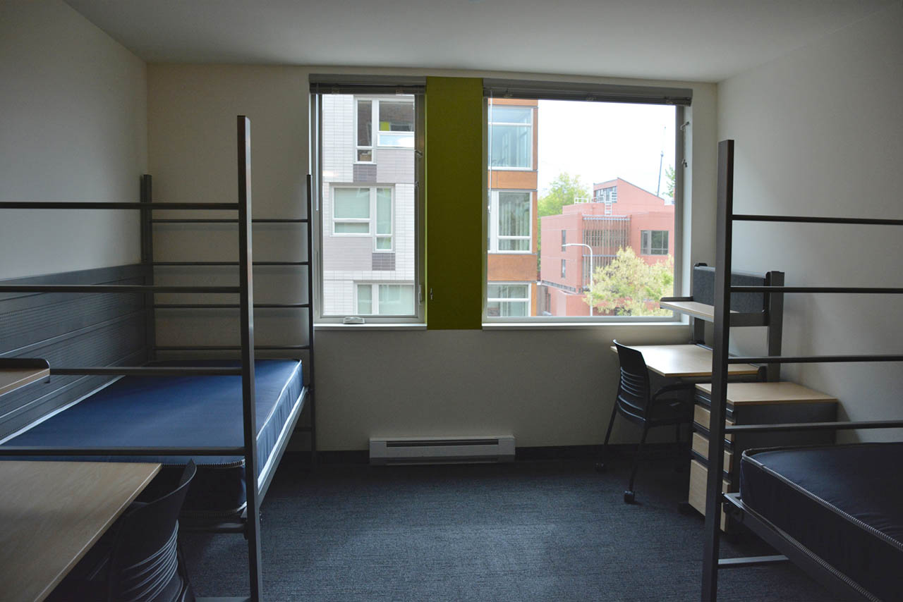 Room with two twin beds and desks.