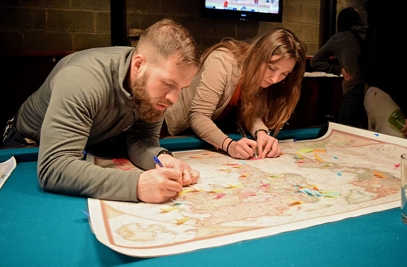Two people write on a map.