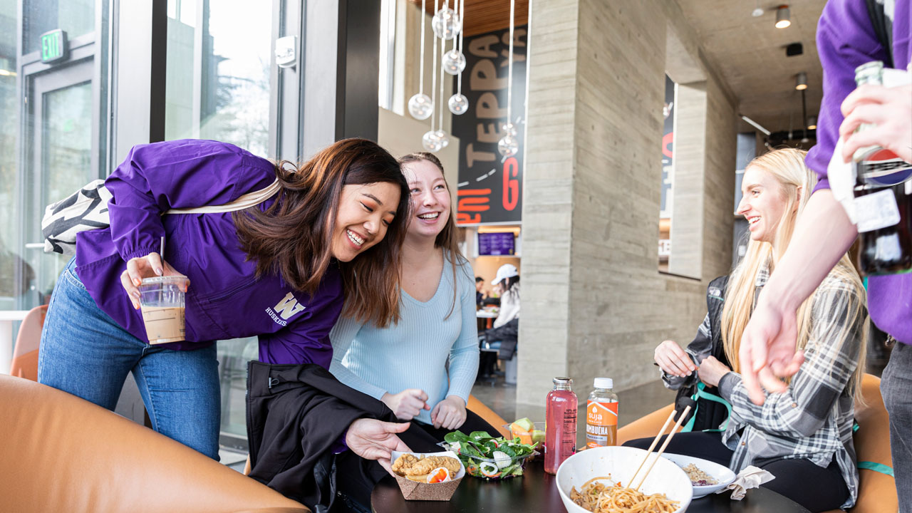 Students smiling and laughing in dining hall.