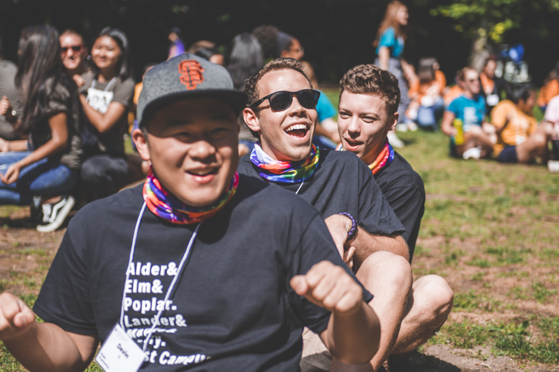 Students sitting on the grass in matching shirts.