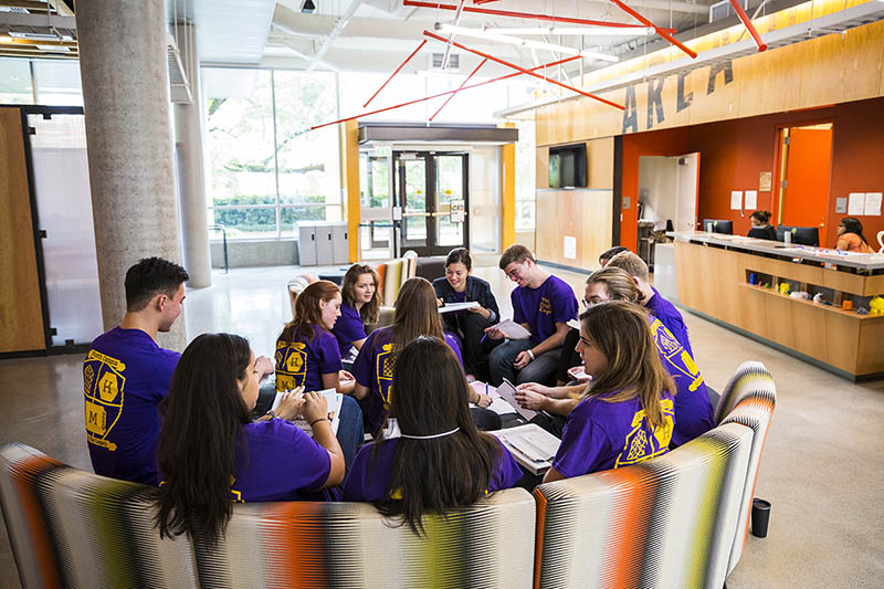 A group of students in matching shirts sitting in Area 01.