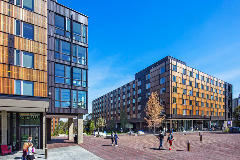 A group of students walking between two buildings.