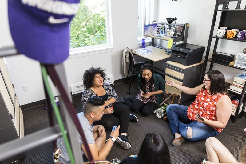 Students enjoying a card game in their dorm room