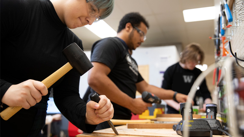 Students working with hand tools in The 8.