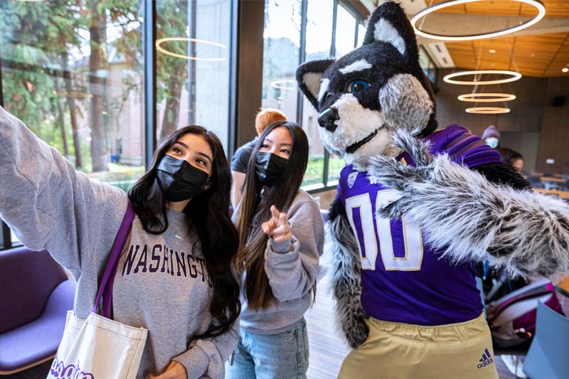 Residents in the Denny Room taking a selfie with Harry the Husky