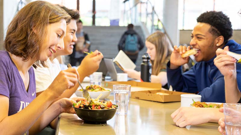 Students eating lunch, talking, and reading at Local Point