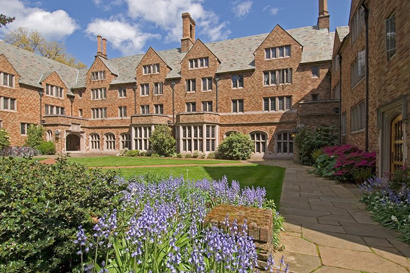 A brick building with a lawn and flowers.