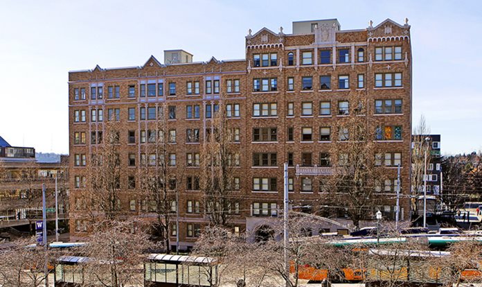 A brick building on a street with trees.