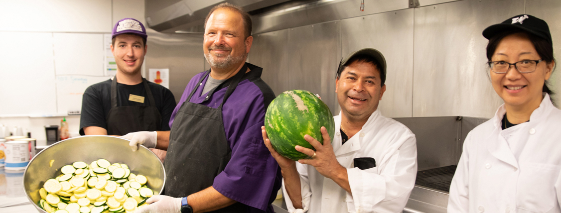 People smiling in a kitchen.