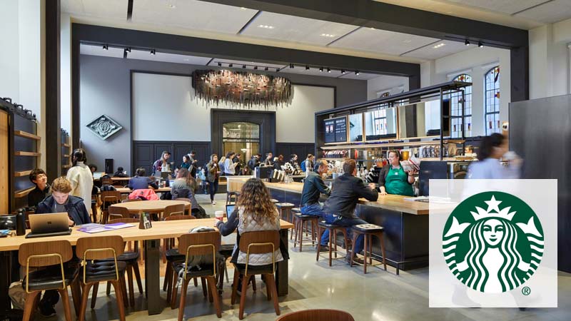 Students sitting at tables and wait in line at Starbucks in Suzzallo Library.