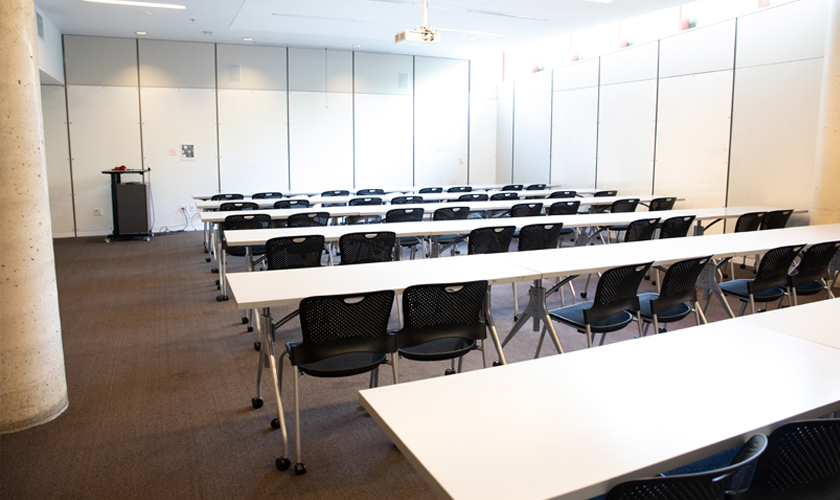 A room with desks, chairs, and podium.