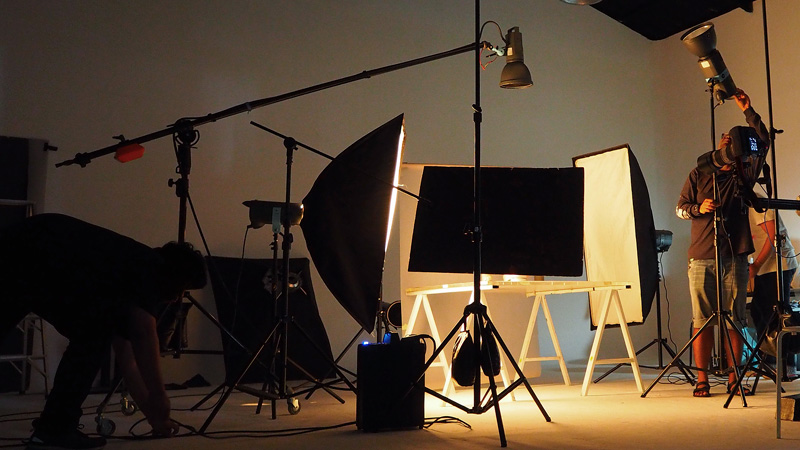 Student adjusting lighting equipment in the Image Lab