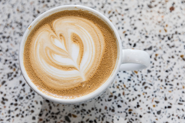 Aerial image of a latte with a leaf drawn in the foam.