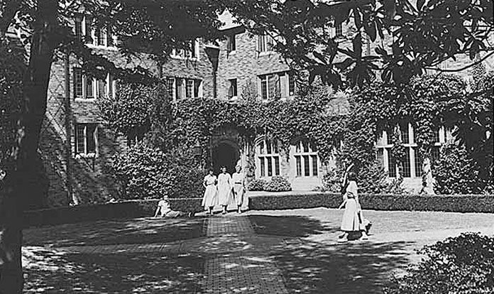 Black and white photograph of students walking through the courtyard of Hansee Hall.