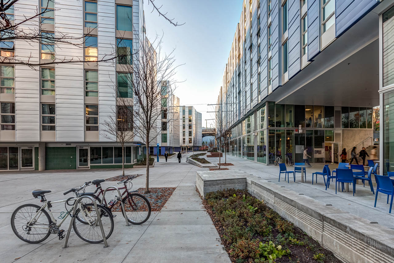 Gray building with trees and bikes.