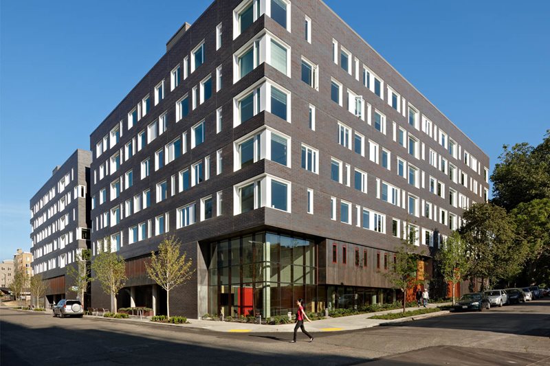 A gray building with trees.