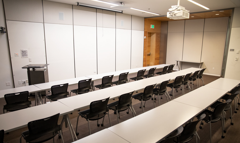 A room with desks, chairs, and podium.