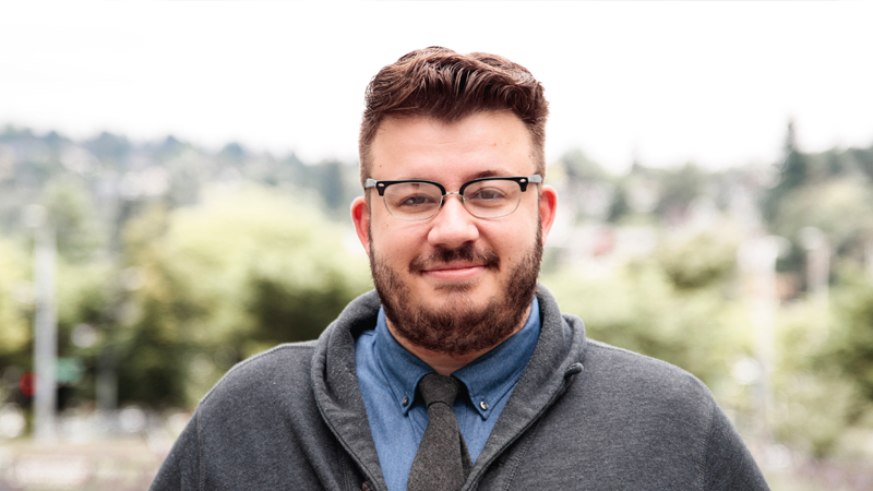 Man in gray sweater smiling