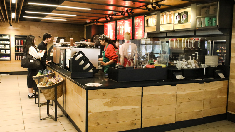 Two students ordering from Starbucks employee.