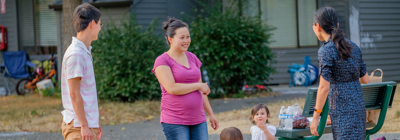 Parents smiling with their children outside Laurel Village Apartments