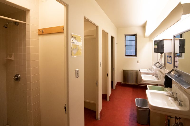 A shared bathroom with sinks and shower stalls.