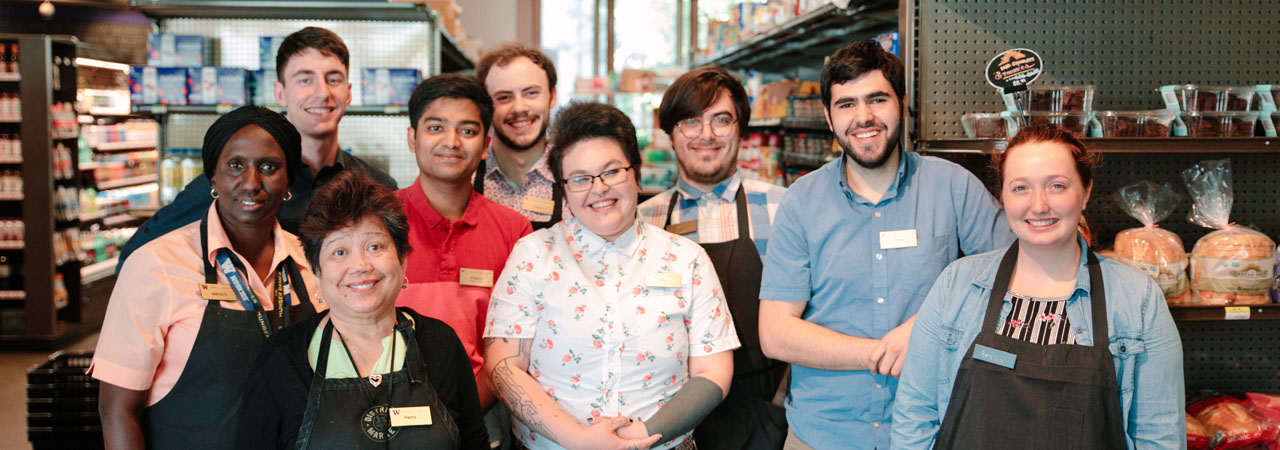 A group of people smiling in District Market Alder.