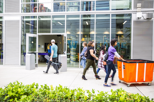 Students carry their belongings past Mercer Court on move in day