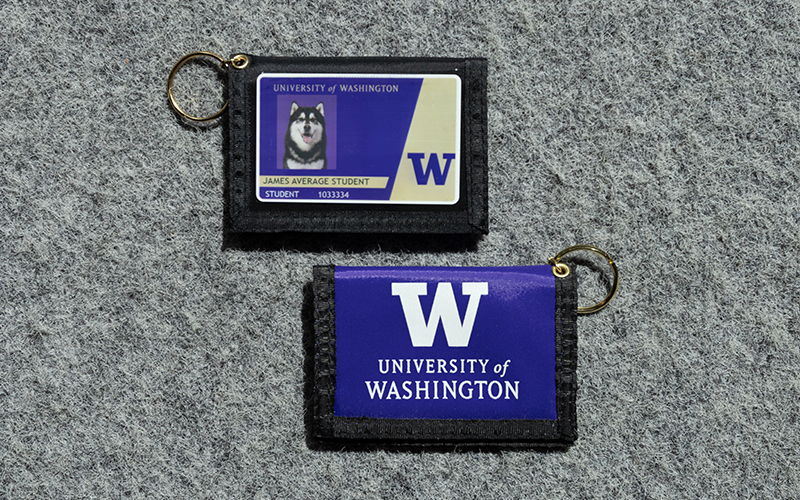 Two wallets with a keyring and a clear plastic sleeve in the front that shows the Husky Card and the University of Washington logo on the back.